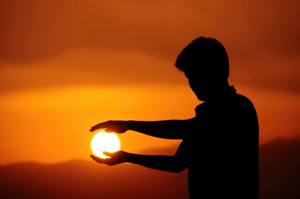 Teen with adhd cupping the sunset with his hands
